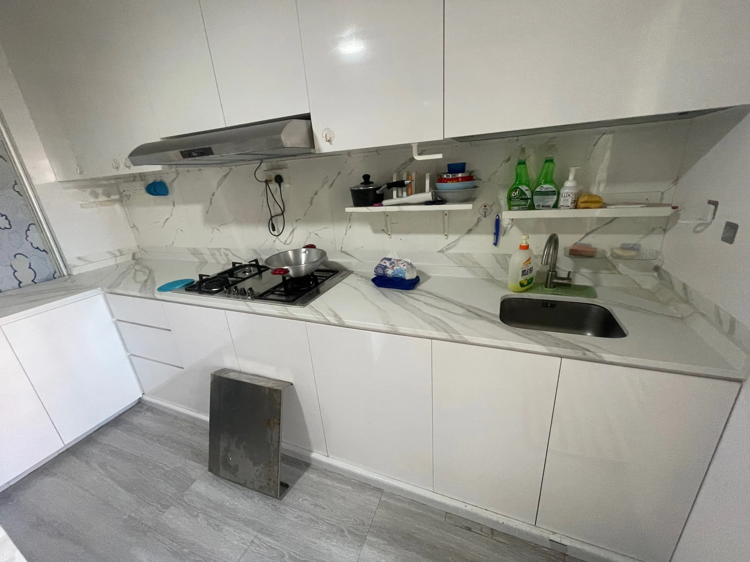 A Choa Chu Kang HDB kitchen after resurfacing, with white cabinet fronts and a light worktop.