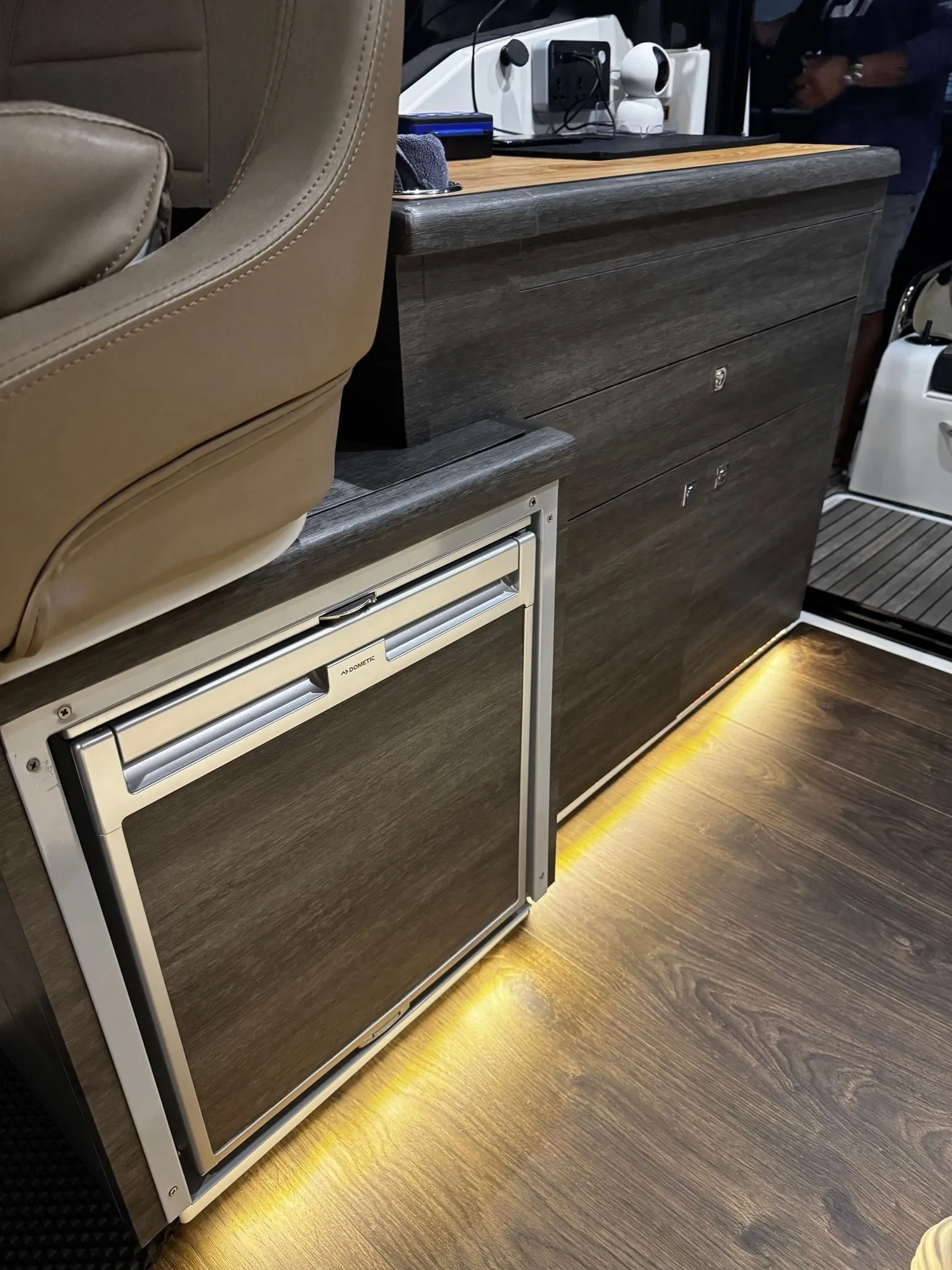 A yacht saloon interior resurfaced in a cool grey woodgrain, with the original fittings kept.